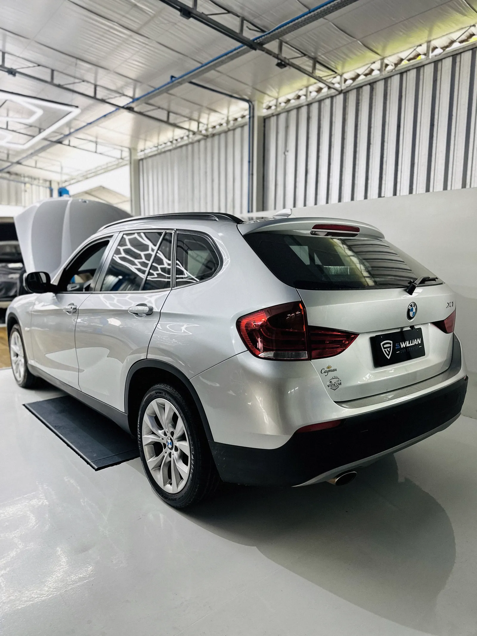 BMW X1 prata visto de trás, com película de proteção no vidro