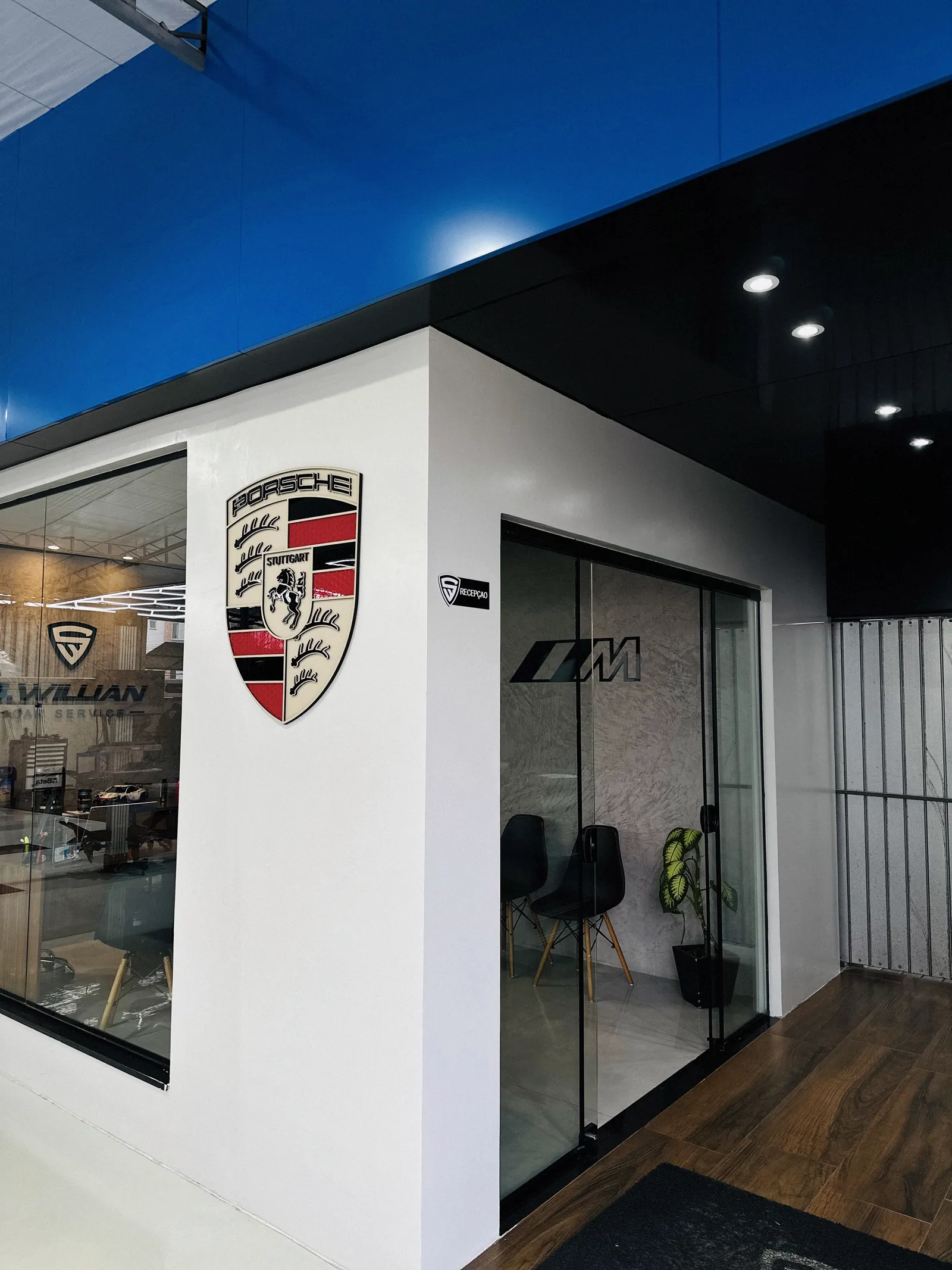 Brasão Porsche na parede da sala de espera da oficina