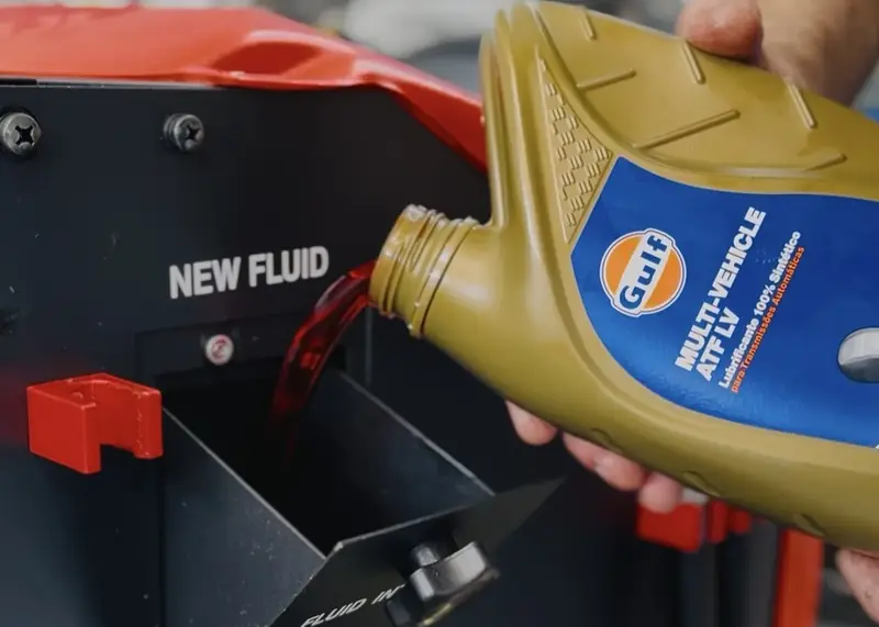 Óleo ATF sendo despejado na máquina de troca de óleo do câmbio automático da oficina