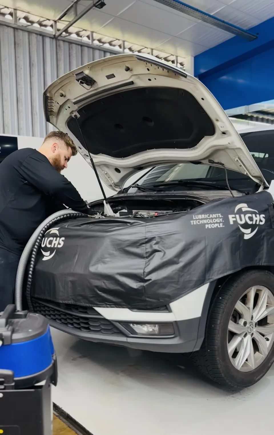 Máquina de descarbonização ligada ao motor, com o capô aberto e a capa de proteção