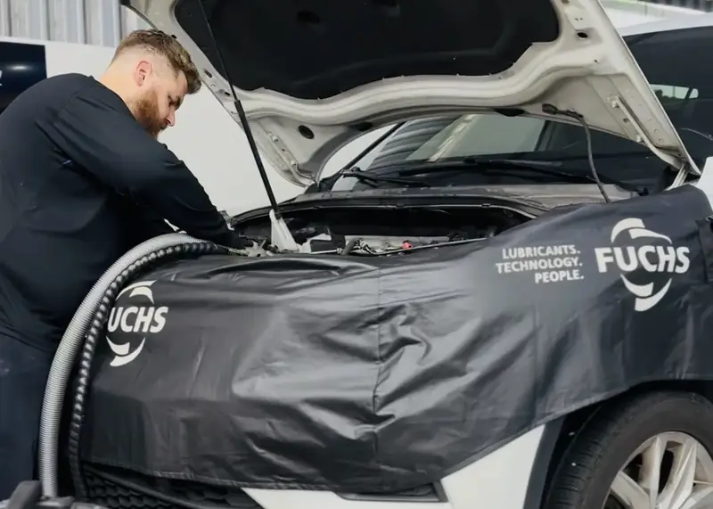 Máquina de descarbonização ligada ao motor, com o capô aberto e a capa de proteção