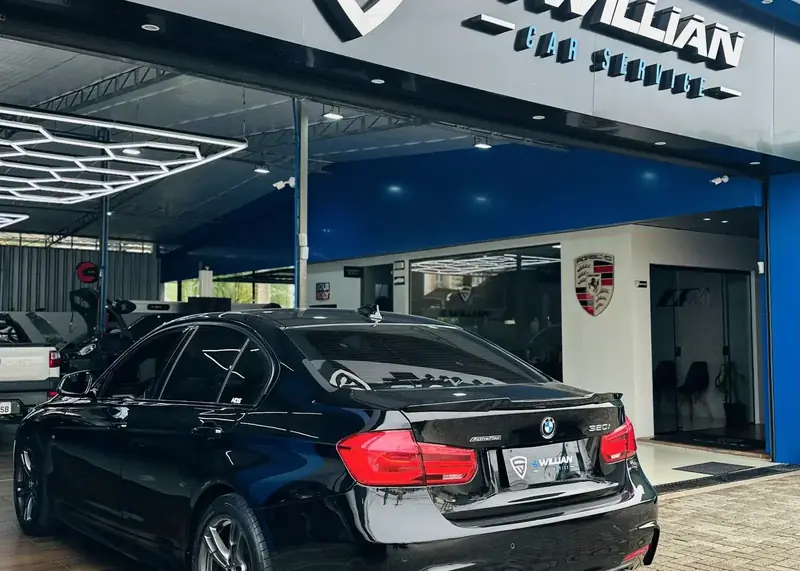 Fachada da S. Willian Car Service com o letreiro da oficina e um BMW 320i estacionado na calçada.