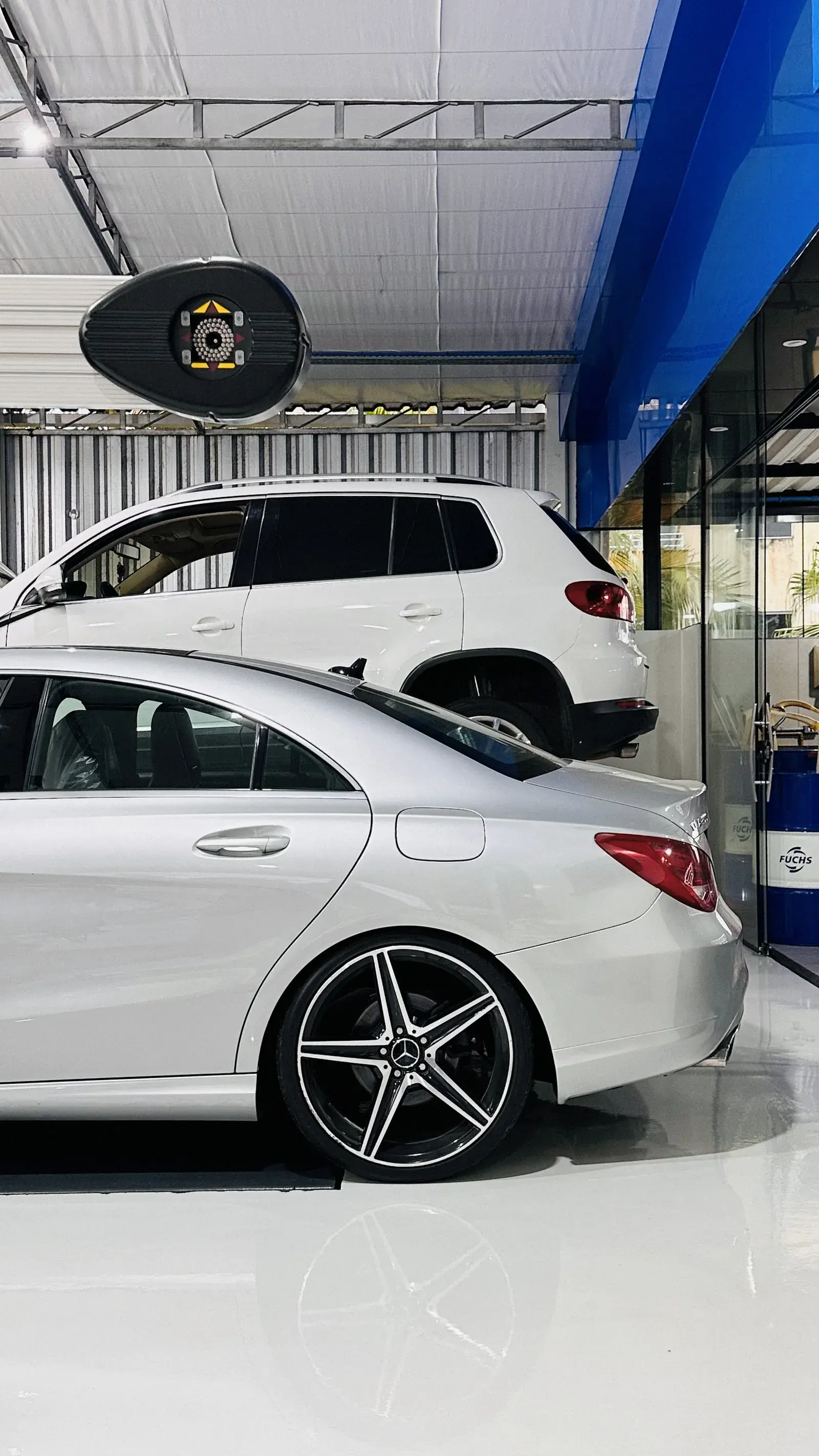 Mercedes-Benz CLA branco em perfil traseiro em primeiro plano, Volkswagen Tiguan branco ao fundo