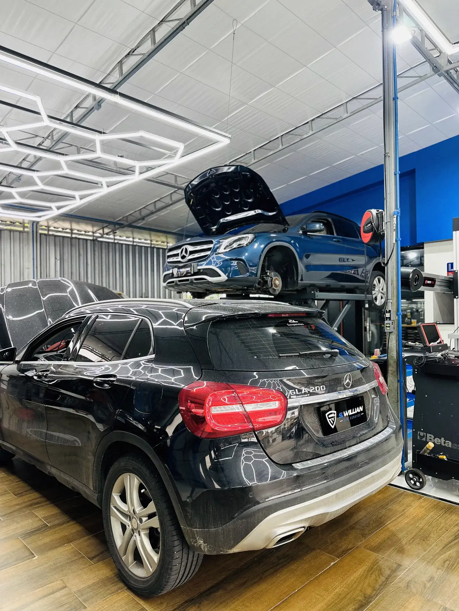 Mercedes-Benz GLA preta com película de proteção, elevador ao fundo