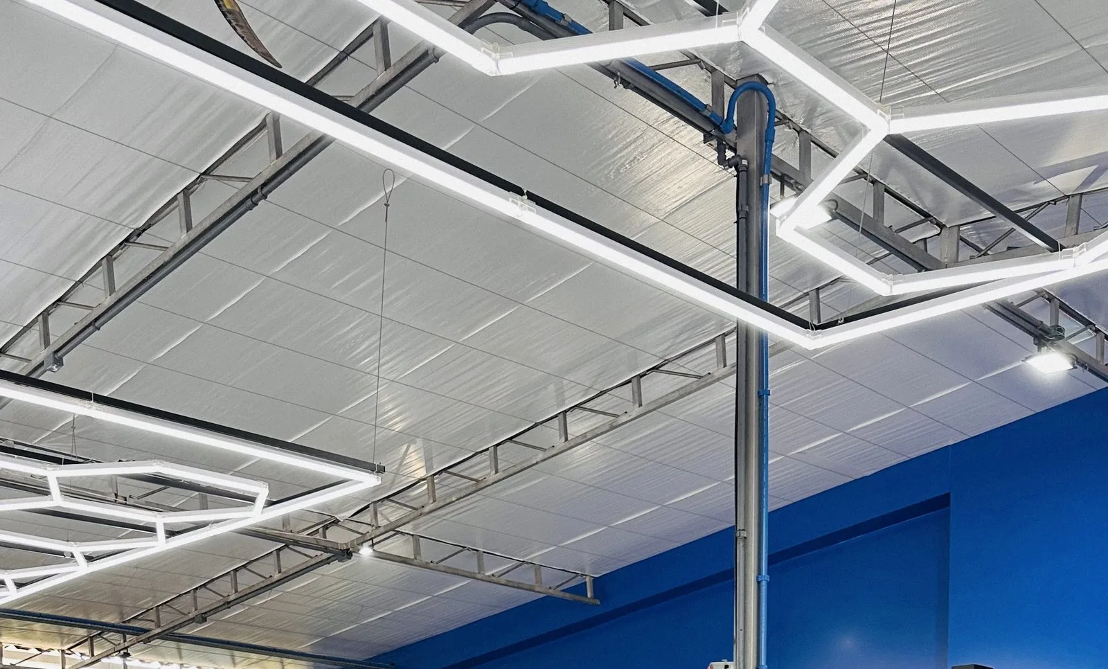 Teto com iluminação hexagonal de LED sobre os elevadores da S. Willian Car Service