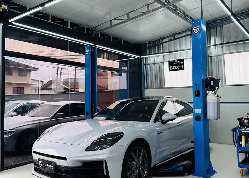 Porsche Panamera no boxe 1 da oficina, sob o teto hexagonal de LED.