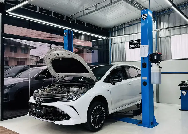 Toyota Corolla com o capô aberto no Box 1, sob teto hexagonal de LED.