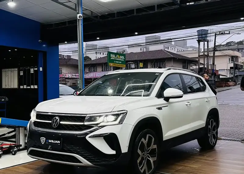 Volkswagen branco sob o teto hexagonal de LED da S. Willian Car Service, em Joinville.